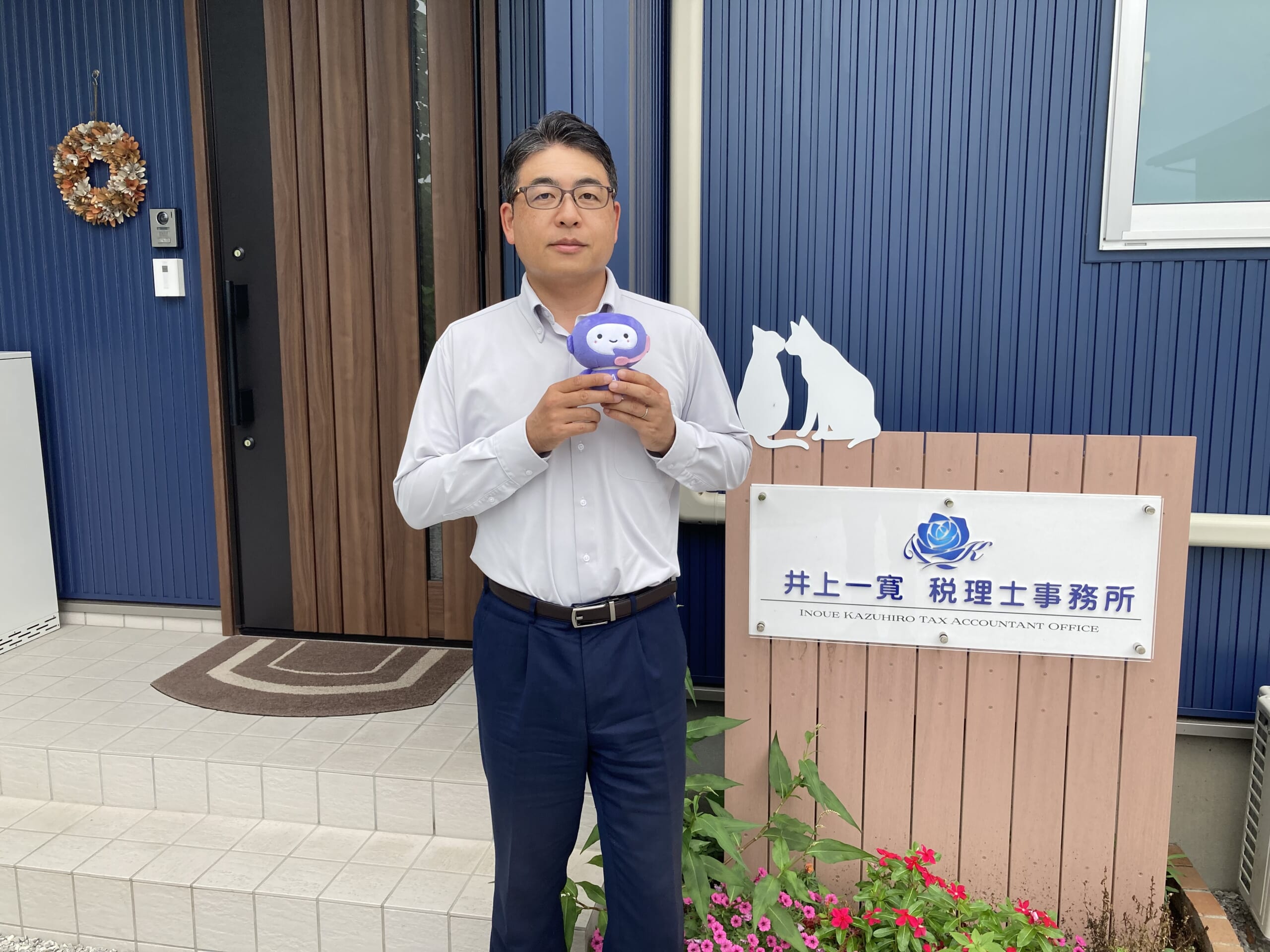 事務所の前に立つ井上一寛税理士。
